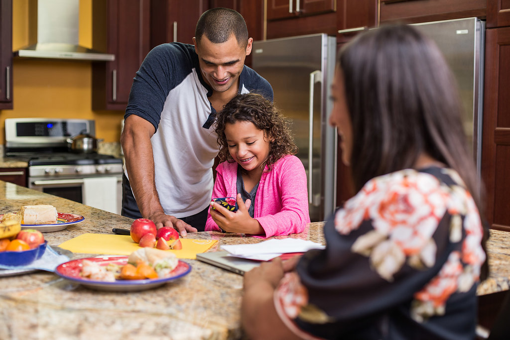 Veteran and his family using a tablet at home.